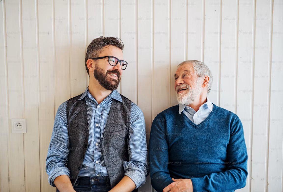 Two colleagues of different generations smiling at each other